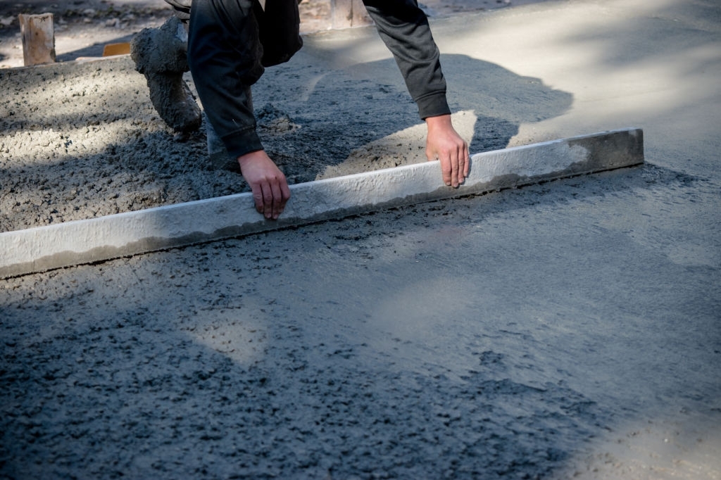 Равнение товарного бетона марки М300 класса В22,5 монолитной площадки правилом